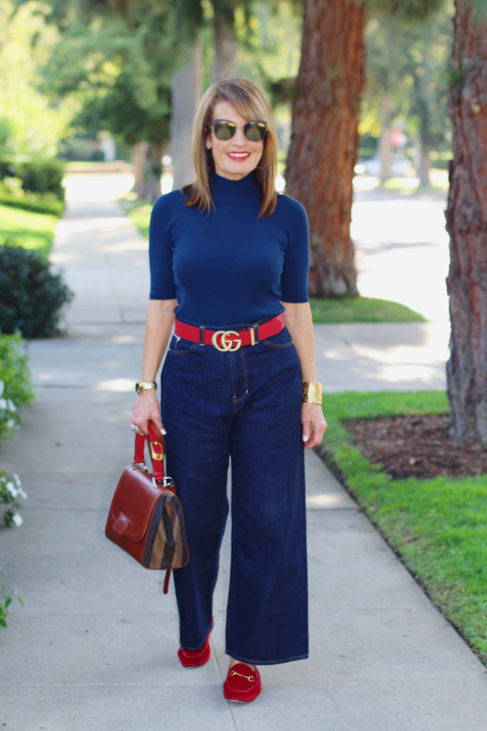 A World Curated Sweater, Fig London Jeans, Gucci Belt and Loafers, Fendi Handbag, Hamilton Watch, Vintage YSL Cuff, Mykita Shades.