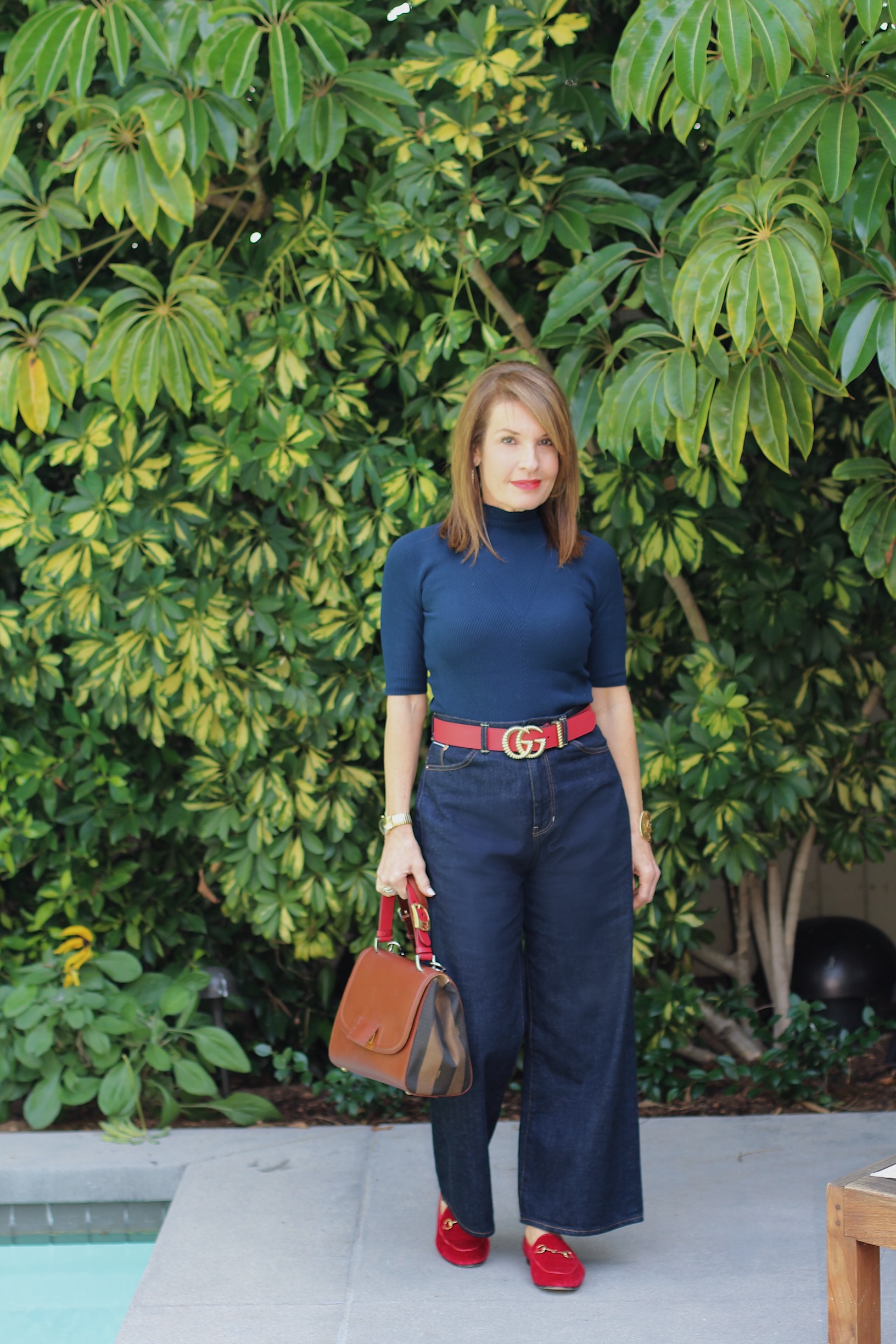 A World Curated Sweater, Fig London Jeans, Gucci Belt and Loafers, Fendi Handbag, Hamilton Watch, Vintage YSL Cuff, Mykita Shades.