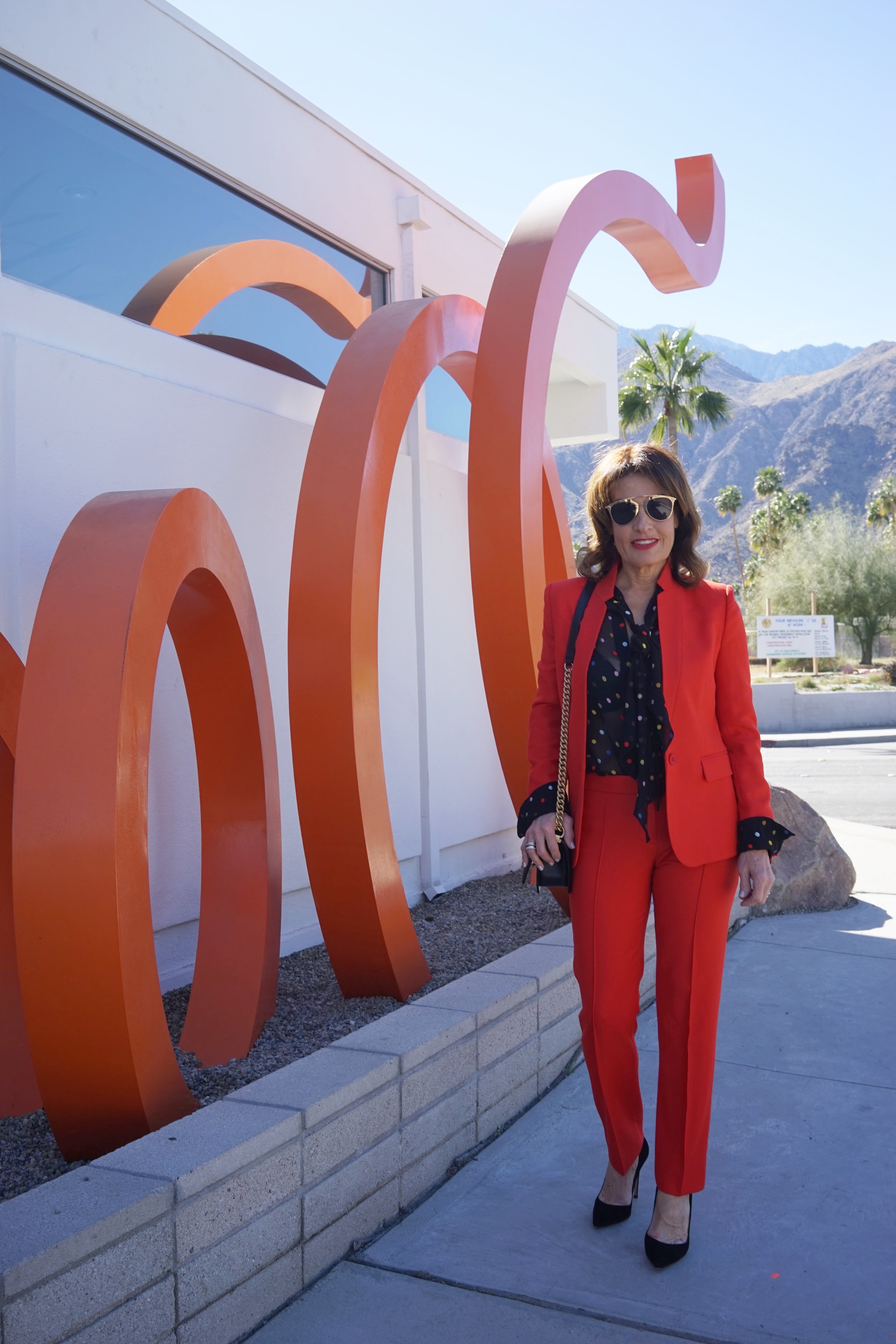  Stella McCartney jacket and pants, Givenchy blouse, Natori bra, Chanel handbag, Gianvito Rossi heels, Christian Dior shades. 