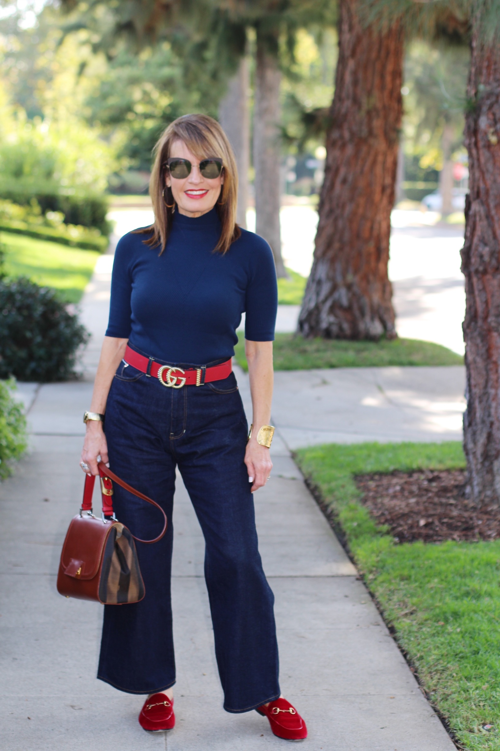 A World Curated Sweater, Fig London Jeans, Gucci Belt and Loafers, Fendi Handbag, Hamilton Watch, Vintage YSL Cuff, Mykita Shades.