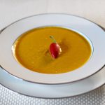 Golden Turmeric Vegetable Soup With Cashews and Curry Spices.