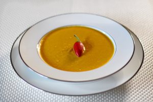 Golden Turmeric Vegetable Soup With Cashews and Curry Spices.