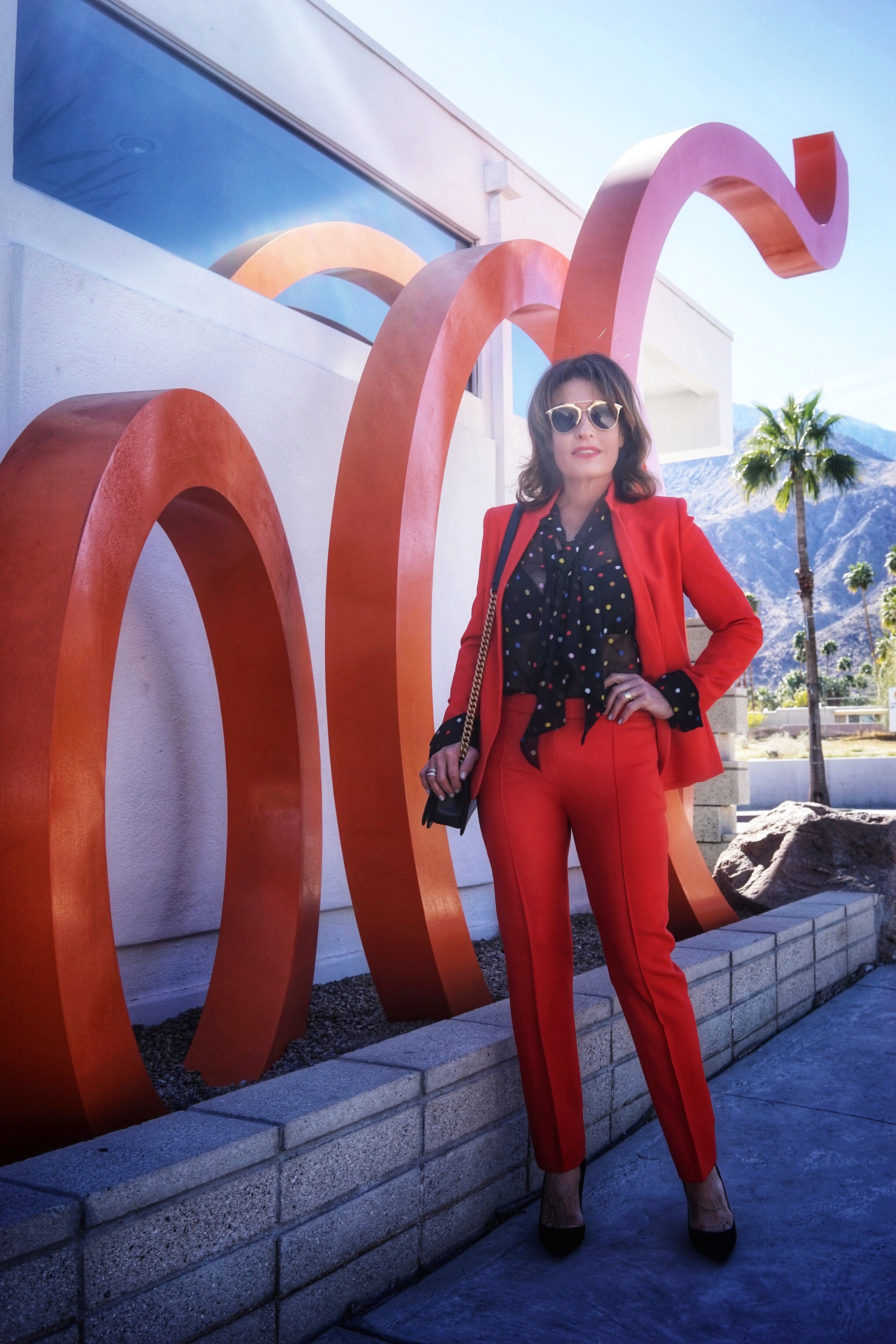  Stella McCartney jacket and pants, Givenchy blouse, Natori bra, Chanel handbag, Gianvito Rossi heels, Christian Dior shades.