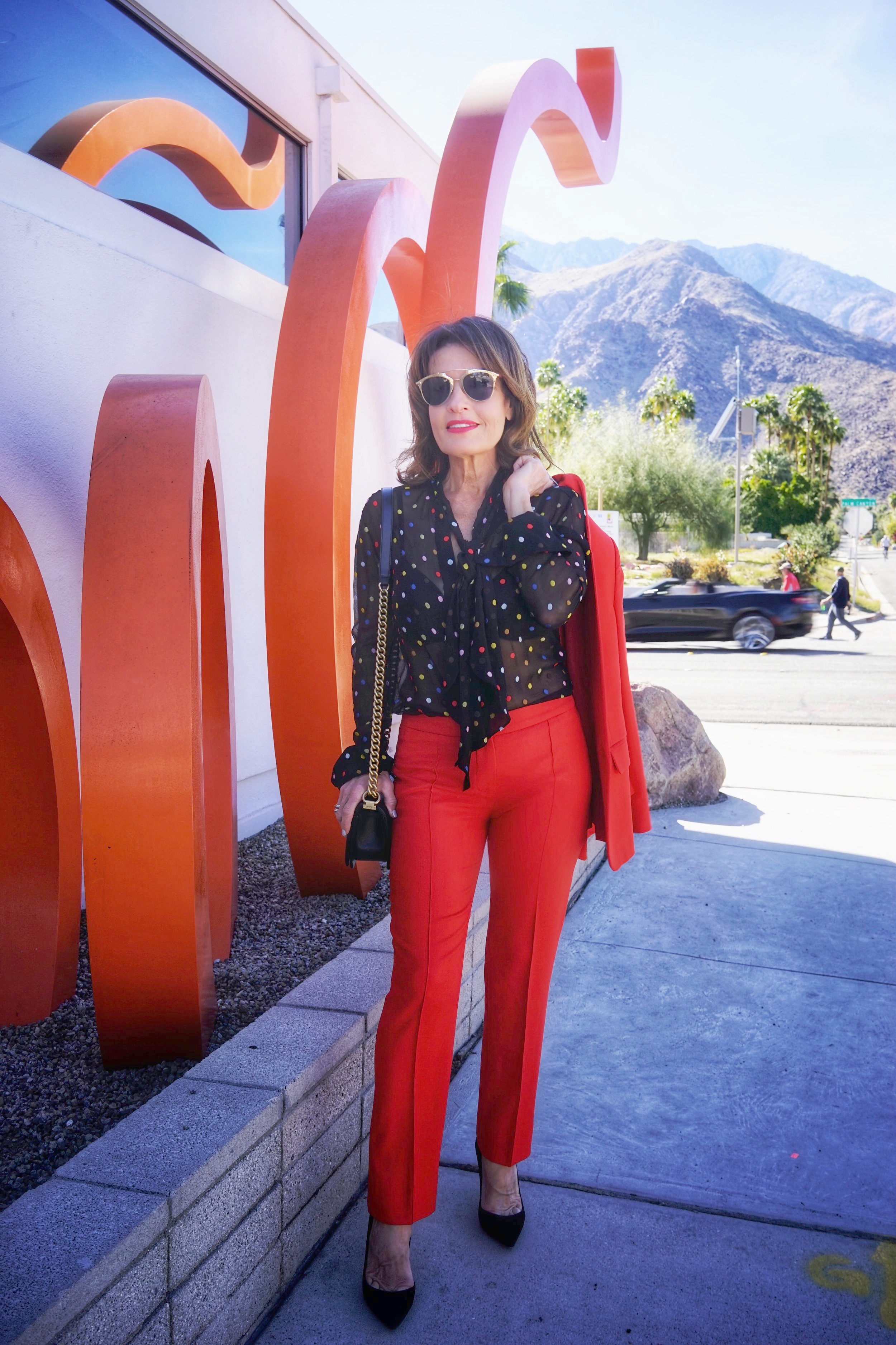  Stella McCartney jacket and pants, Givenchy blouse, Natori bra, Chanel handbag, Gianvito Rossi heels, Christian Dior shades.