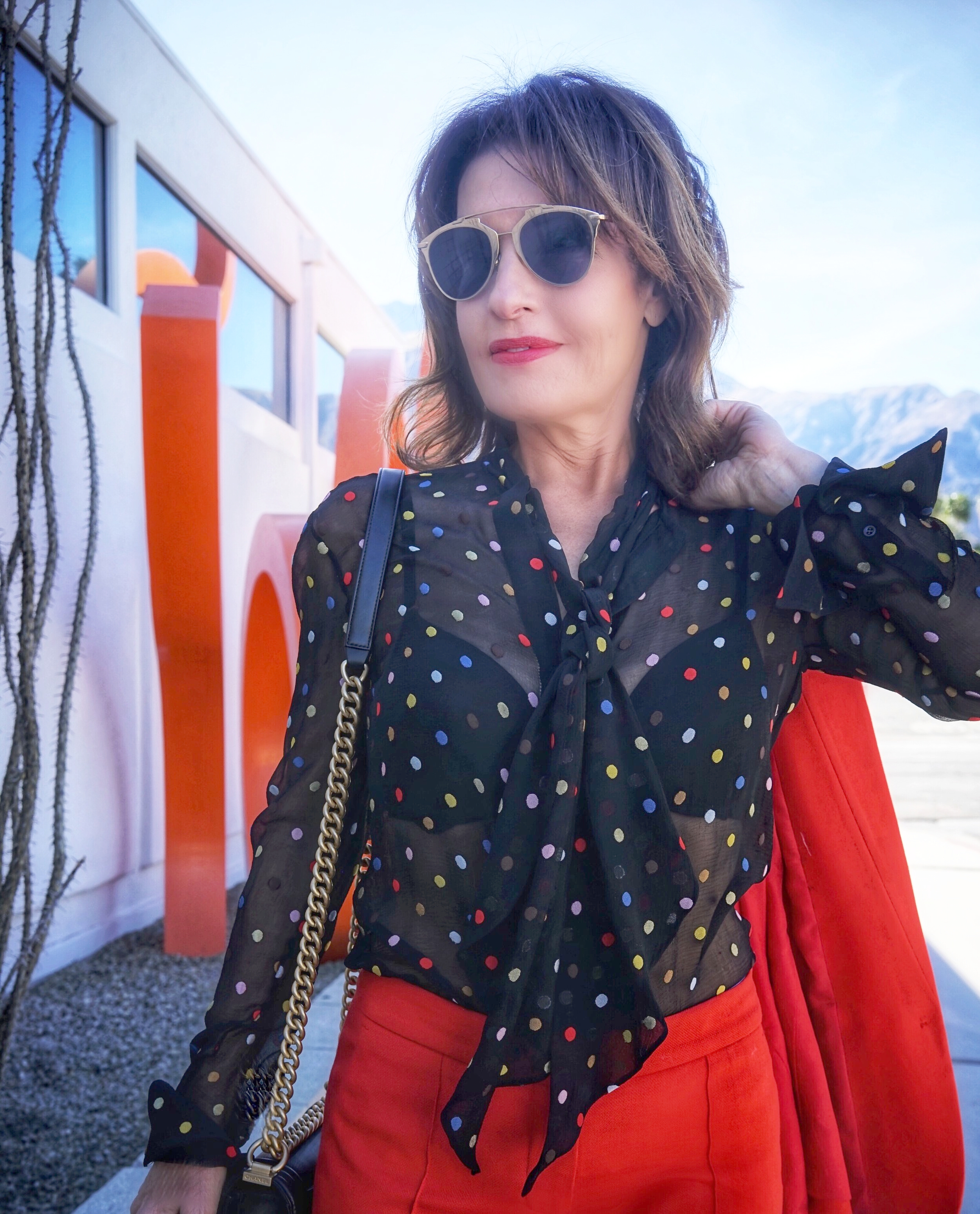  Stella McCartney jacket and pants, Givenchy blouse, Natori bra, Chanel handbag, Gianvito Rossi heels, Christian Dior shades.